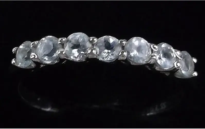 Silver ring with embedded stones on a black background