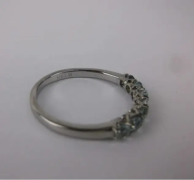 Silver ring with gemstones on a light pink background