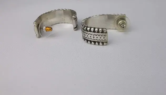 Two silver hoop earrings on a light gray background