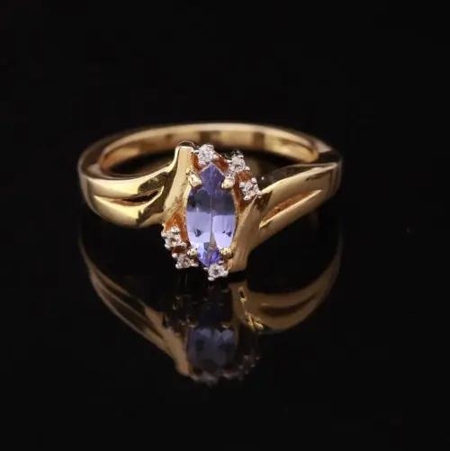 Gold ring with a blue gemstone on a black background