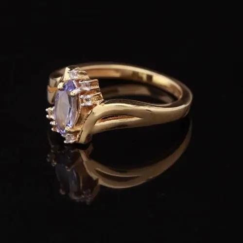 Gold ring with a central gemstone on a black background