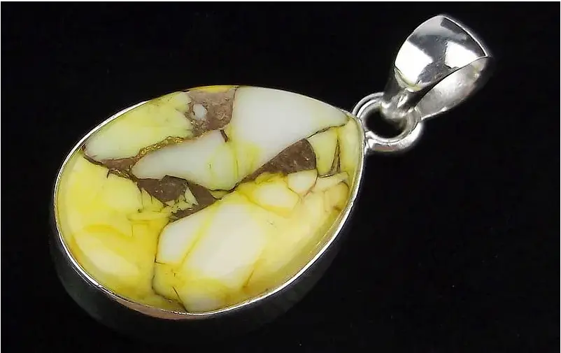 Teardrop-shaped amber pendant with silver setting on a black background