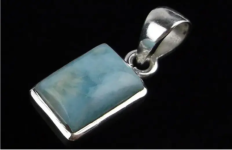 Silver pendant with a rectangular blue stone on a black background